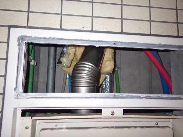 今回の給湯器は、上方排気タイプです。  枠上の点検口を開けて煙突を取り外します。